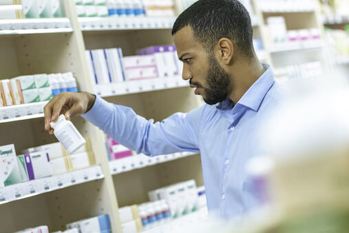 Beard man choosing supplement in drugstore